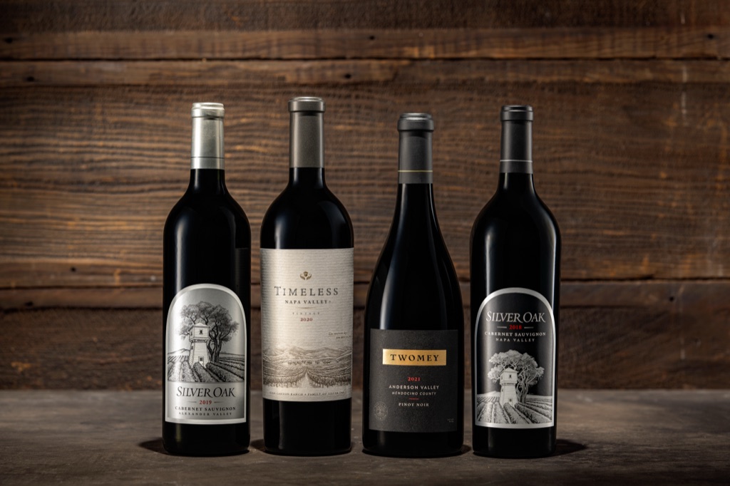 Four-bottle lineup of Silver Oak Alexander Valley and Napa Valley cabernet with Twomey Anderson Valley pinot noir on dark wood