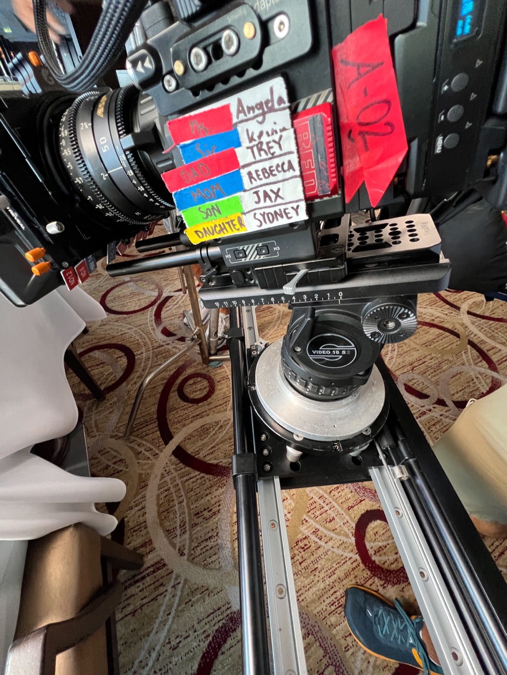Cinema camera on a slider with hand-labeled focus marks for each cast member
