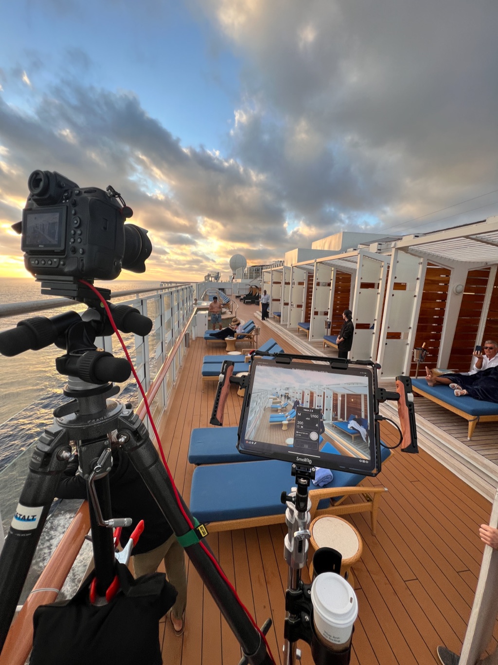 Camera and director's monitor set up on a cruise ship deck at sunrise
