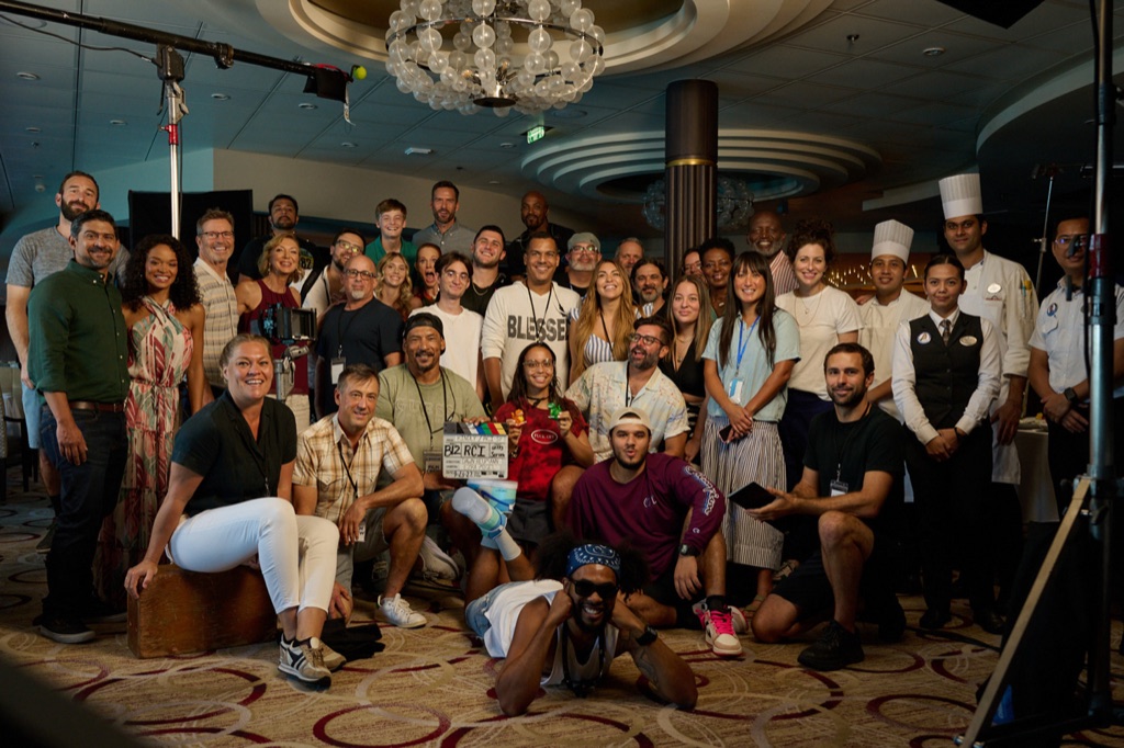 Full cast and crew wrap photo in a cruise ship dining room under the chandelier