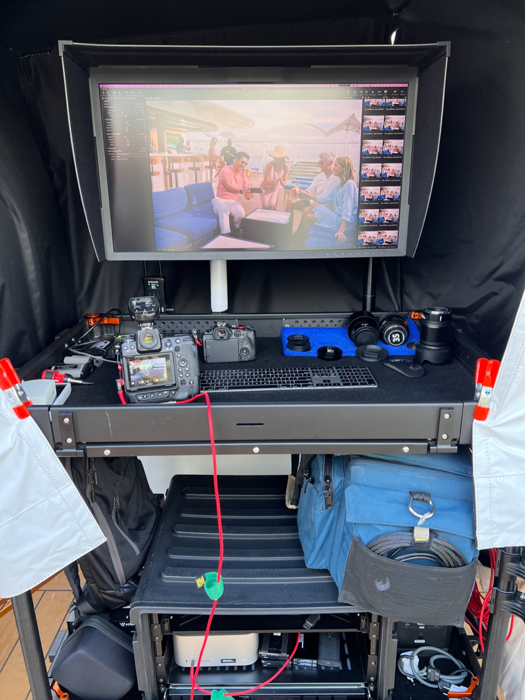 Digital tech cart under a blackout tent with the day's selects on the monitor
