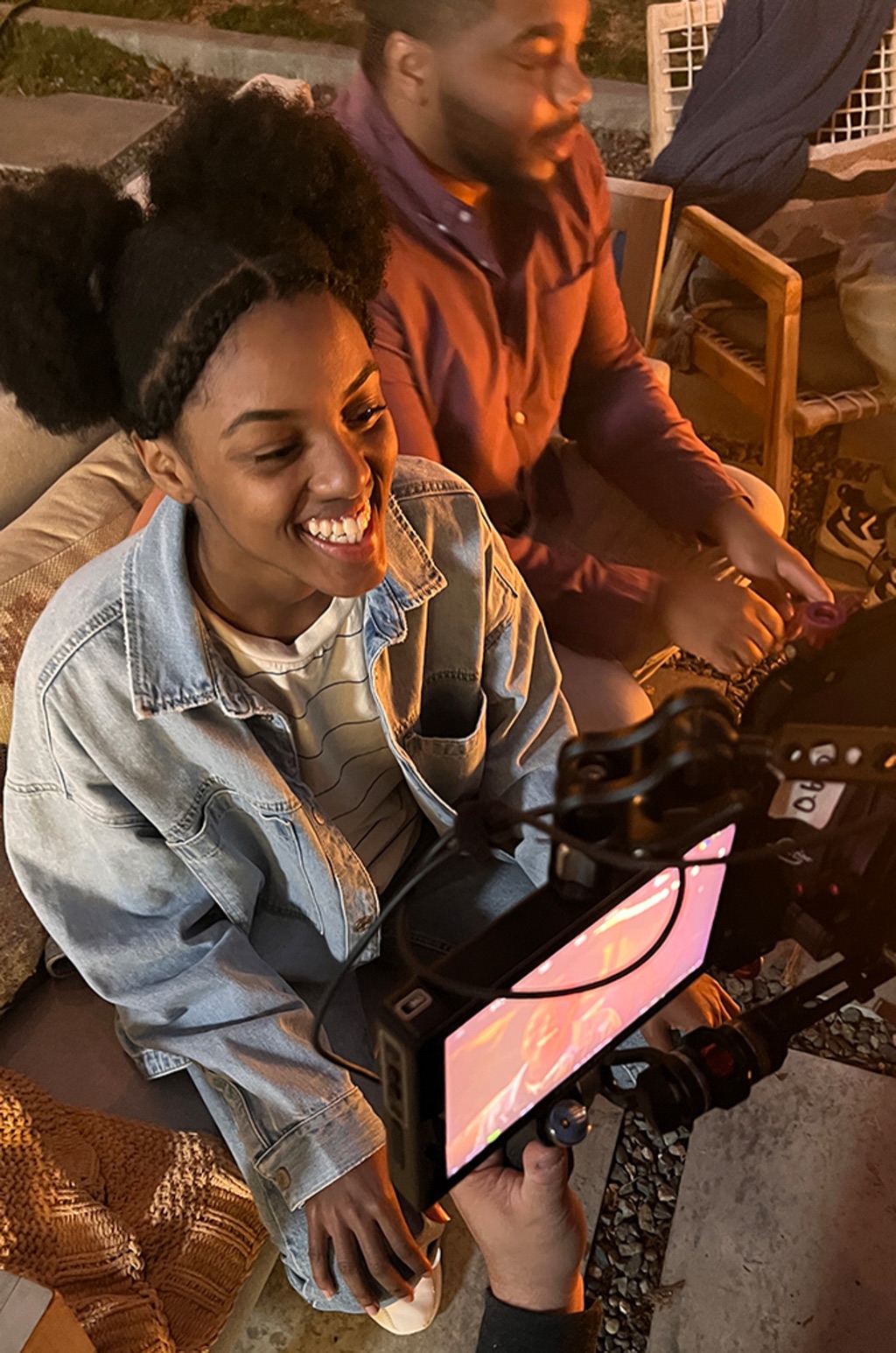 Talent laughing beside the cinema camera between takes on a warm night scene