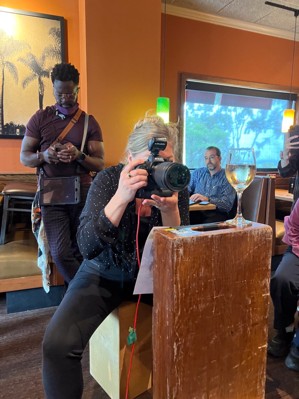 Dawn Heumann shooting from an apple box wedged into a restaurant booth