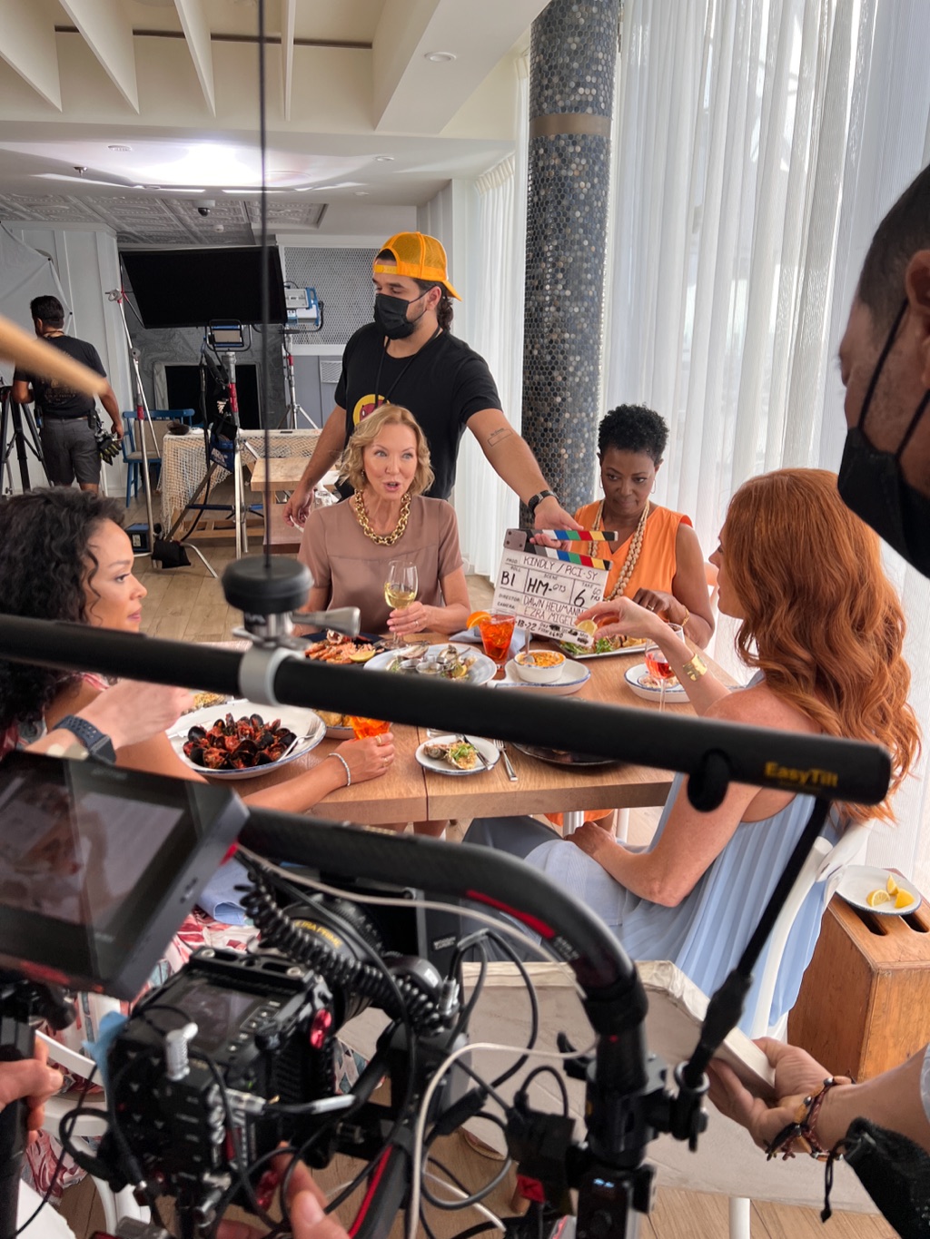 Clapperboard about to mark a restaurant scene with four women at a styled lunch table