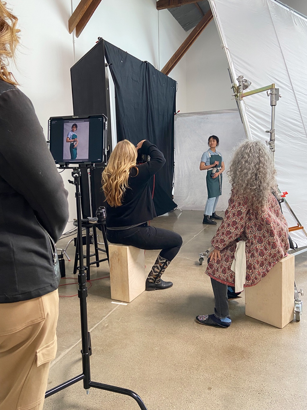 Dawn Heumann shooting a portrait session on white seamless, monitor in the foreground