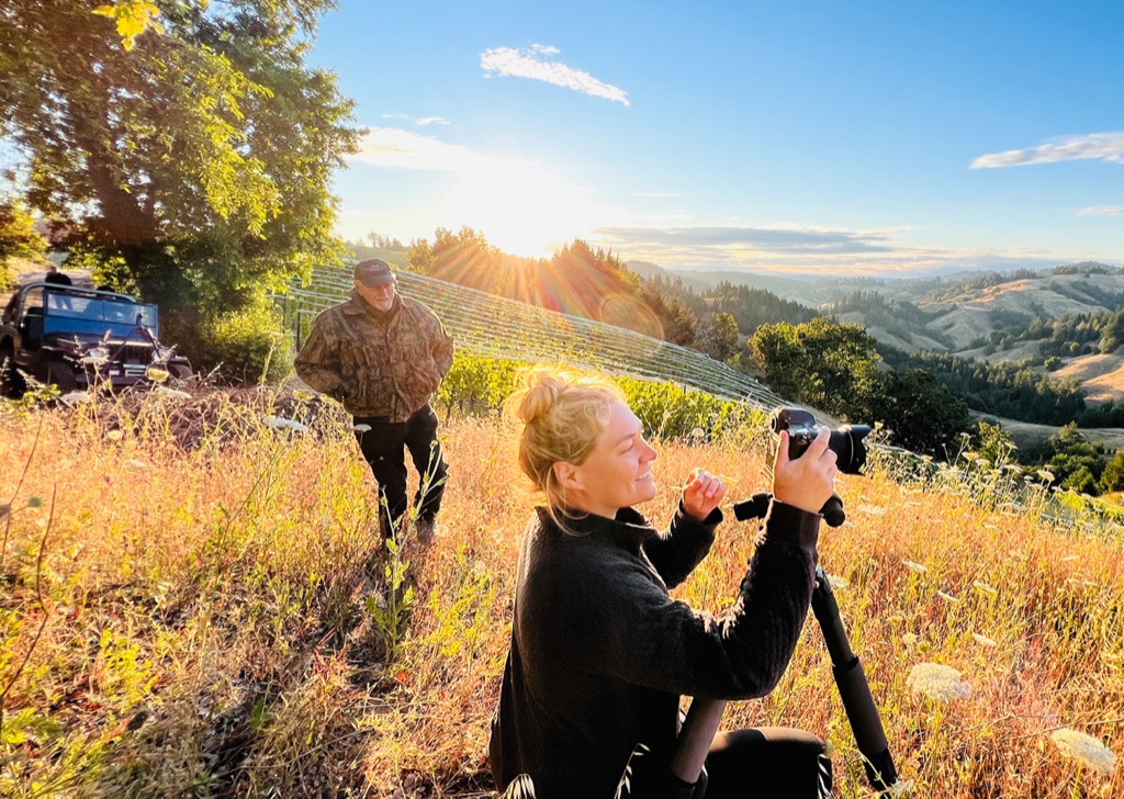 Dawn Heumann photographing sunrise over golden Sonoma County hills from a high ridge on a Dawn Heumann production