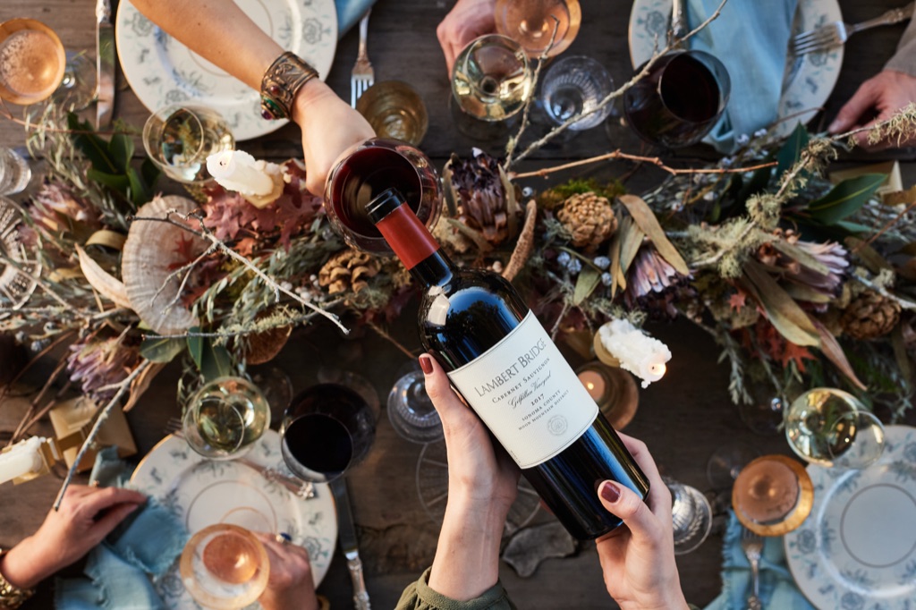 Overhead of Lambert Bridge Gilfillan Vineyard cabernet being poured over an autumn holiday tablescape