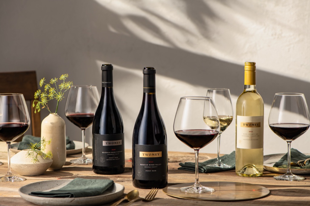 Twomey pinot noirs and sauvignon blanc with poured glasses on a sunlit outdoor table