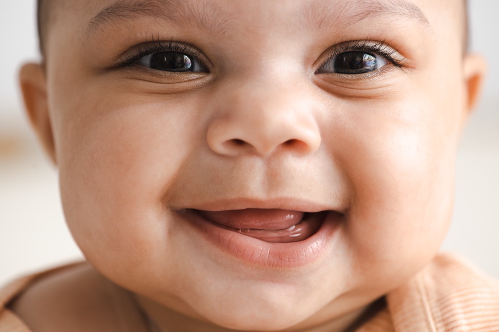 Extreme closeup of a laughing baby's face with long lashes