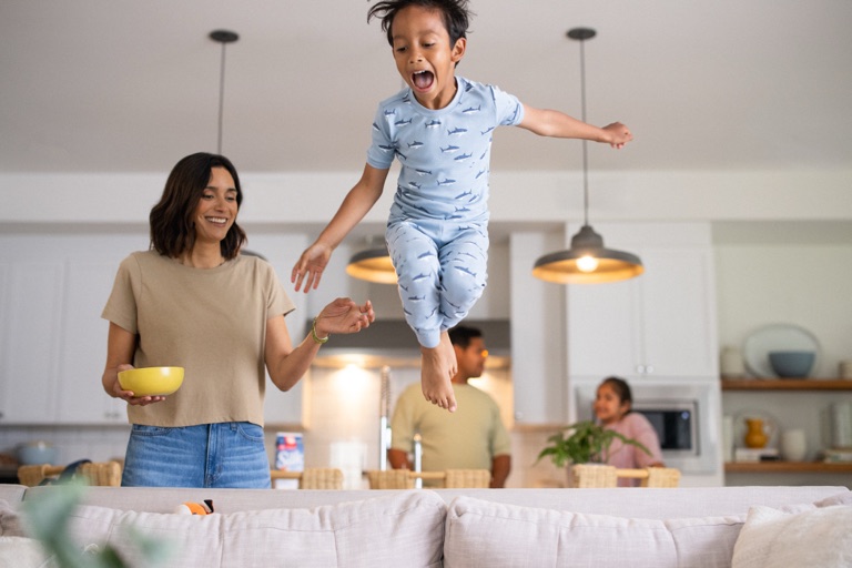 Boy in pajamas jumping on the couch, campaign photography by Dawn Heumann