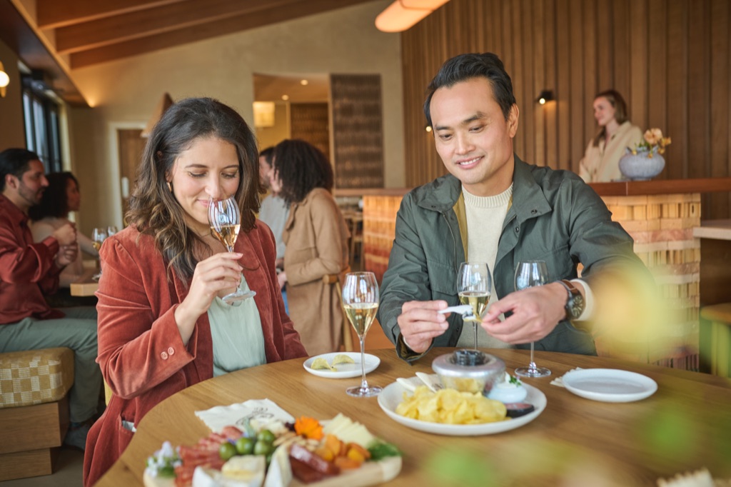 Couple tasting sparkling wine with charcuterie in a tasting room