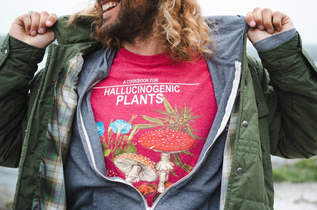 Bearded man laughing as he opens his jacket to reveal a mushroom illustrated t shirt, photographed by Dawn Heumann