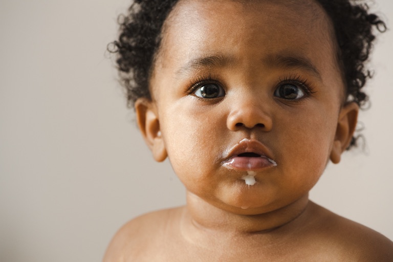 Close-up of a baby with milk on their lips, photographed for a national kids brand by Dawn Heumann