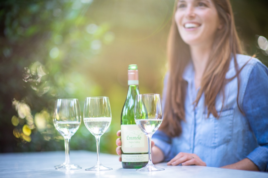 Woman laughing over a garden tasting of Emmolo Napa Valley sauvignon blanc