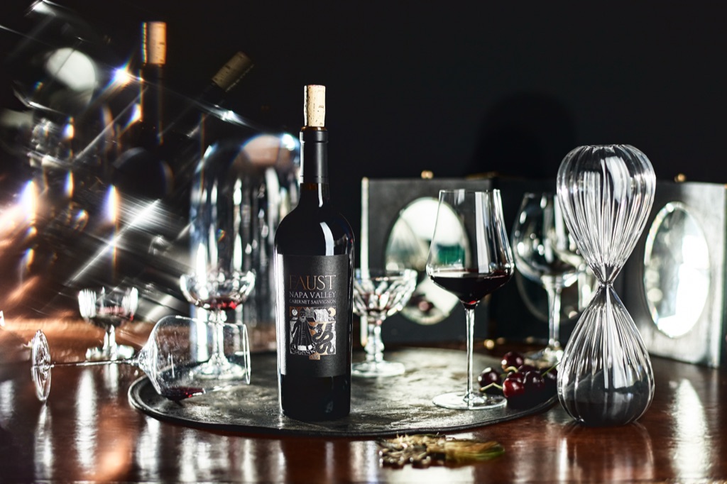 Moody Faust Napa Valley cabernet still life with an hourglass, cherries and low candlelight