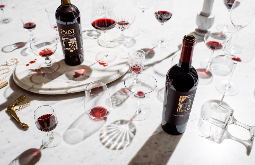 Faust Napa Valley cabernet and The Lure amid scattered crystal and wine-stained marble after a tasting