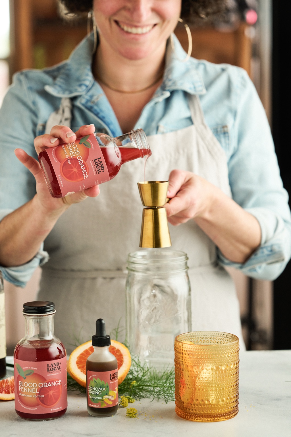 Land and Local syrup pouring into a cocktail glass