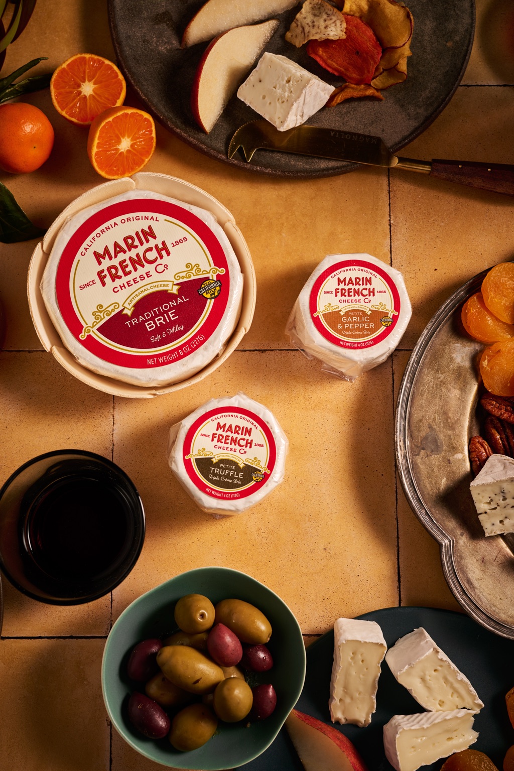 Overhead trio of Marin French Cheese brie on terracotta