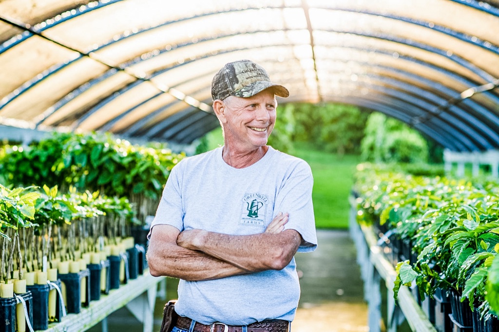 Greenwell Farms Kona coffee farmer with arms crossed in the seedling greenhouse