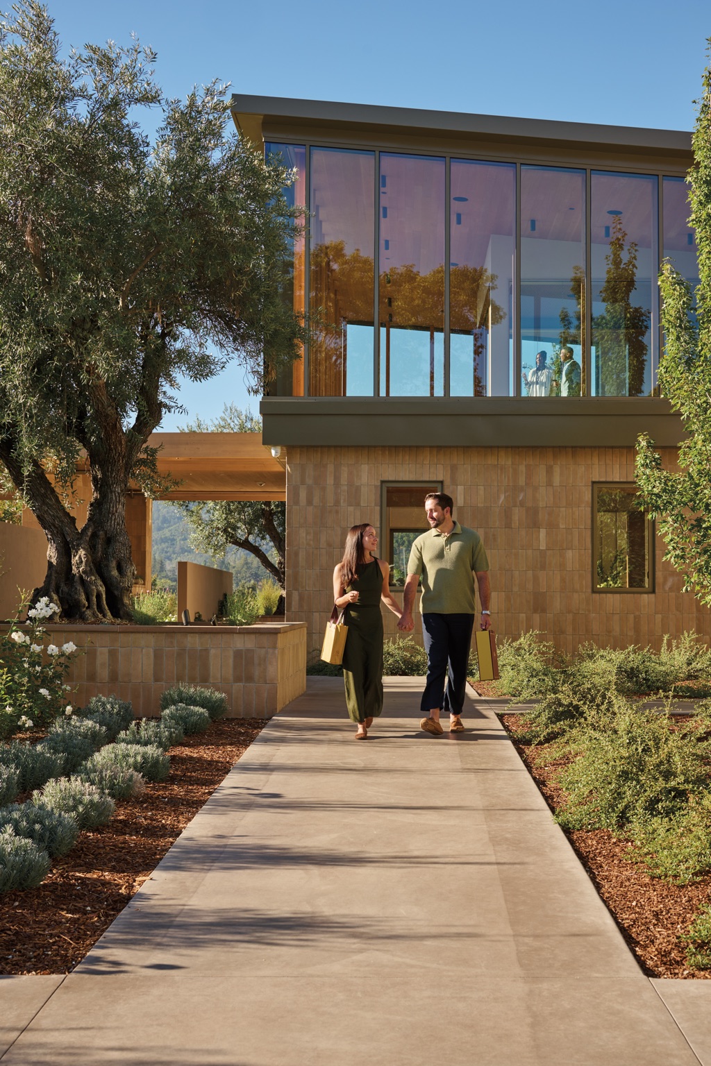 Couple holding hands walking from the Napa Valley winery carrying a Bella Union wine tote and gift box