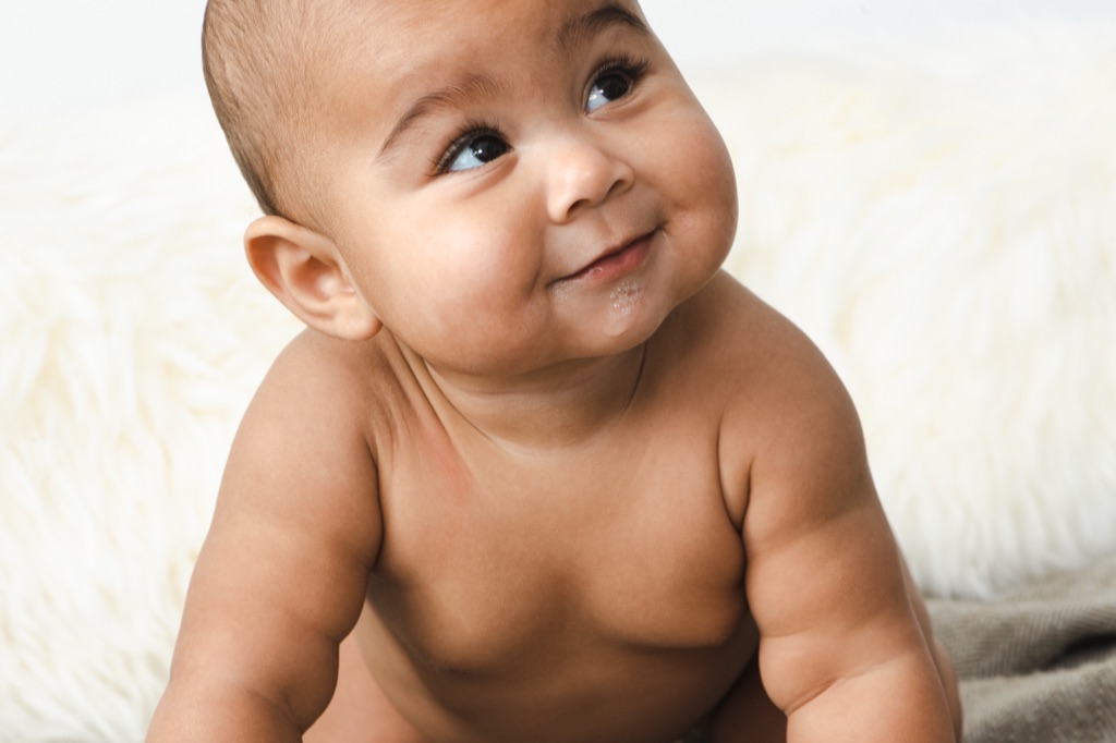 Baby with milk bubbles on their lips glancing to the side with a grin, ByHeart photography, photographed by Dawn Heumann