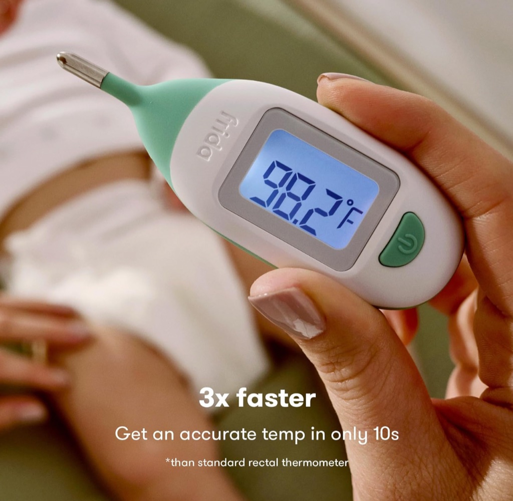 Frida Baby quick-read thermometer digital ad photographed in a parent's hand