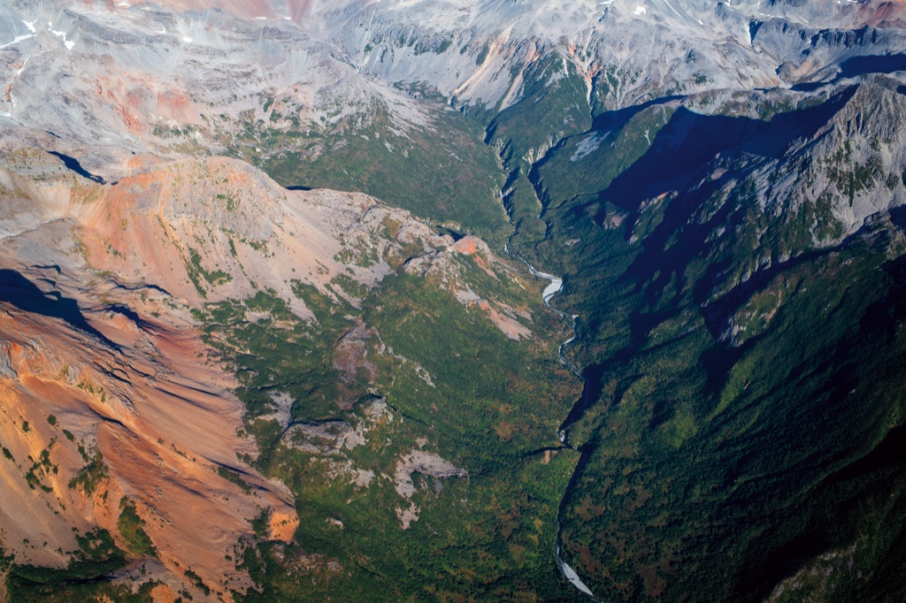 Aerial view of a rugged Alaskan mountain valley with a river winding through a canyon