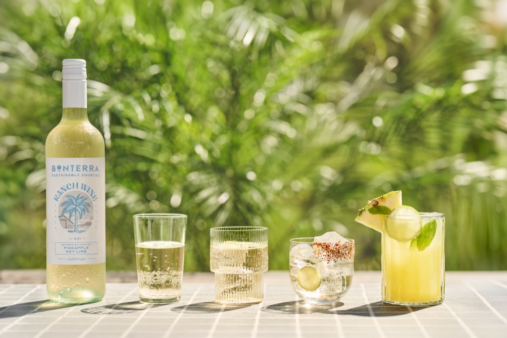 Ranch Wine Pineapple Key Lime bottle with four serve styles on white pool tile, from a simple pour to a chili-salt rim and a pineapple garnish