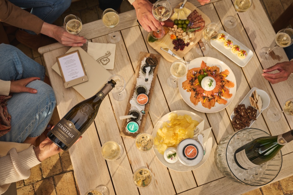 Overhead spread of smoked salmon, caviar, chips, and L'Ermitage Brut with a magnum of Roederer Estate on ice