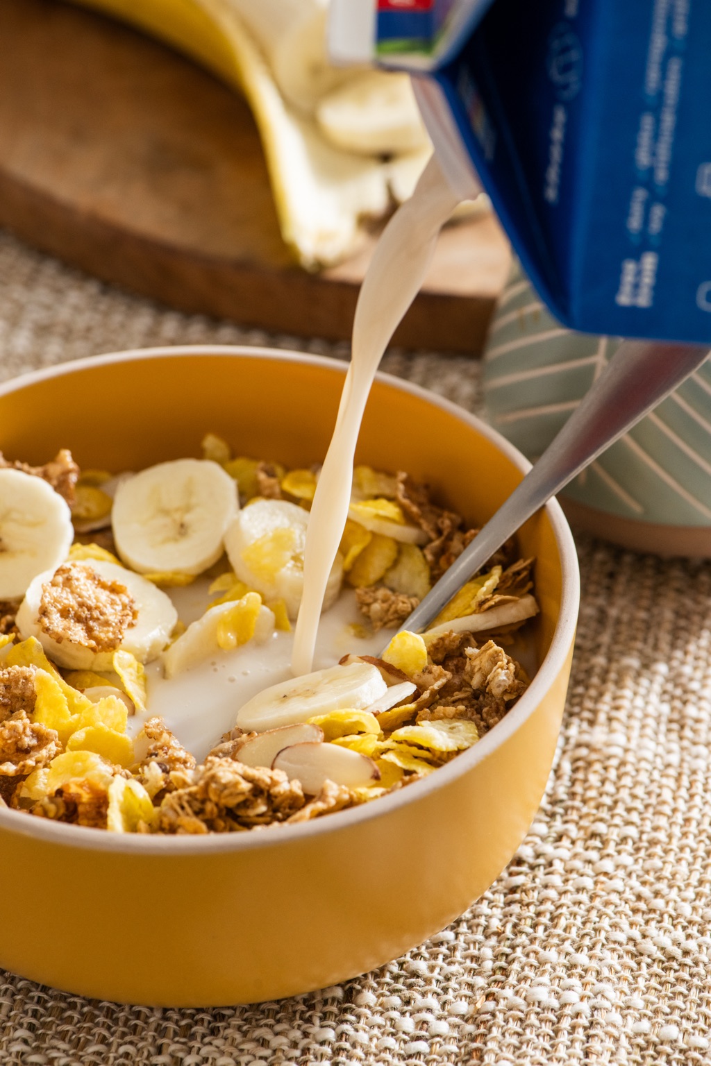 Almondmilk pouring over a bowl of cereal and bananas, Silk campaign detail photographed by Dawn Heumann