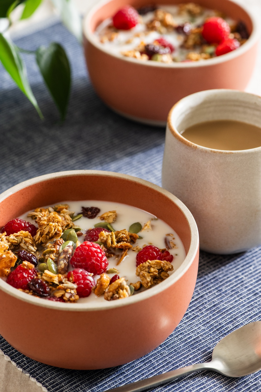 Granola and raspberry bowls with almondmilk and coffee with creamer, Silk campaign still life by Dawn Heumann
