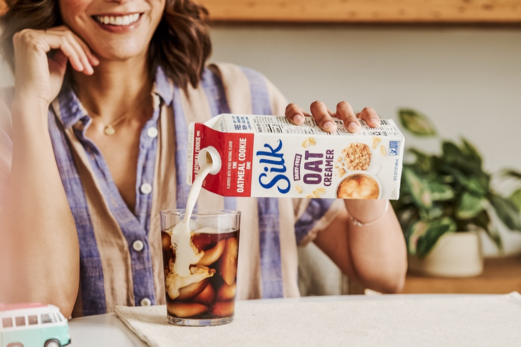 Silk Oat Creamer swirling into a glass of iced coffee, campaign photography by Dawn Heumann