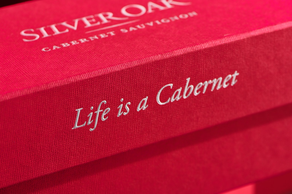 Close-up of the silver embossed Life is a Cabernet lettering on a red linen Silver Oak gift box