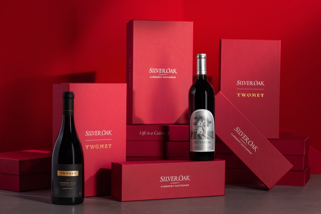Silver Oak and Twomey bottles among stacked red gift boxes against a red backdrop