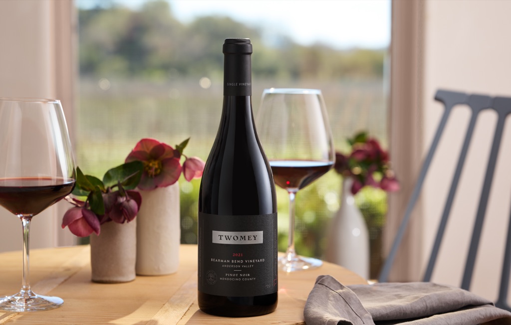 Twomey Bearman Bend Vineyard Anderson Valley Pinot Noir on a table with hellebores and a vineyard view