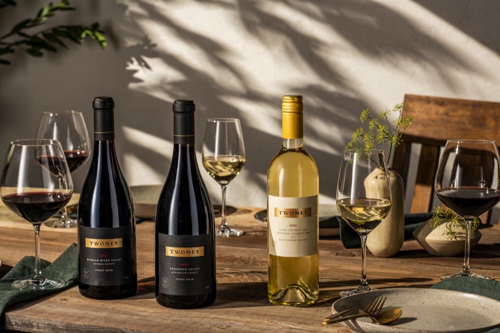 Twomey Russian River Valley and Anderson Valley Pinot Noirs with Sauvignon Blanc on an outdoor table in leaf-dappled light