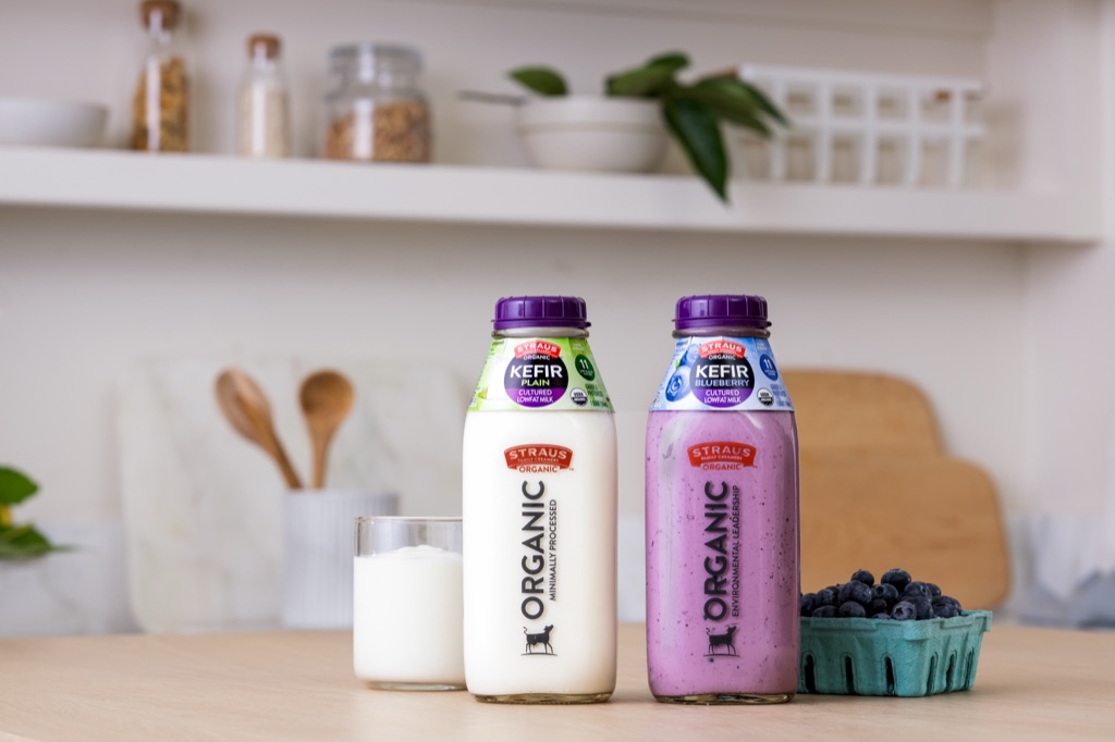 Straus Organic Plain and Blueberry Kefir bottles with a glass of kefir and fresh blueberries
