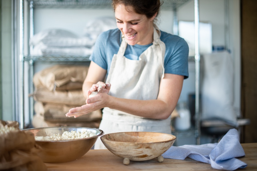 Baker shaping dough by hand in a restaurant bakery kitchen