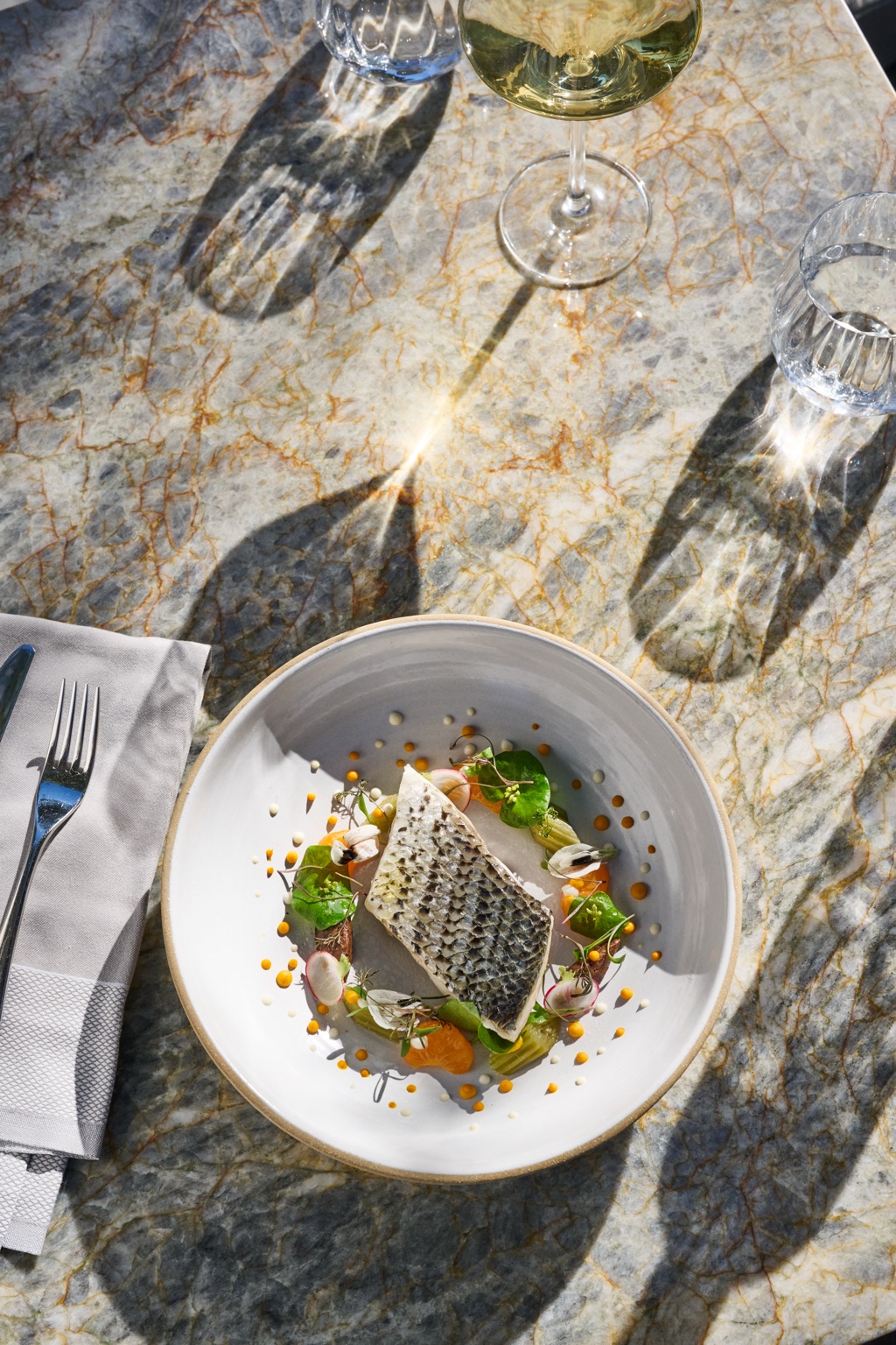 Black bass entree plated on a marble table