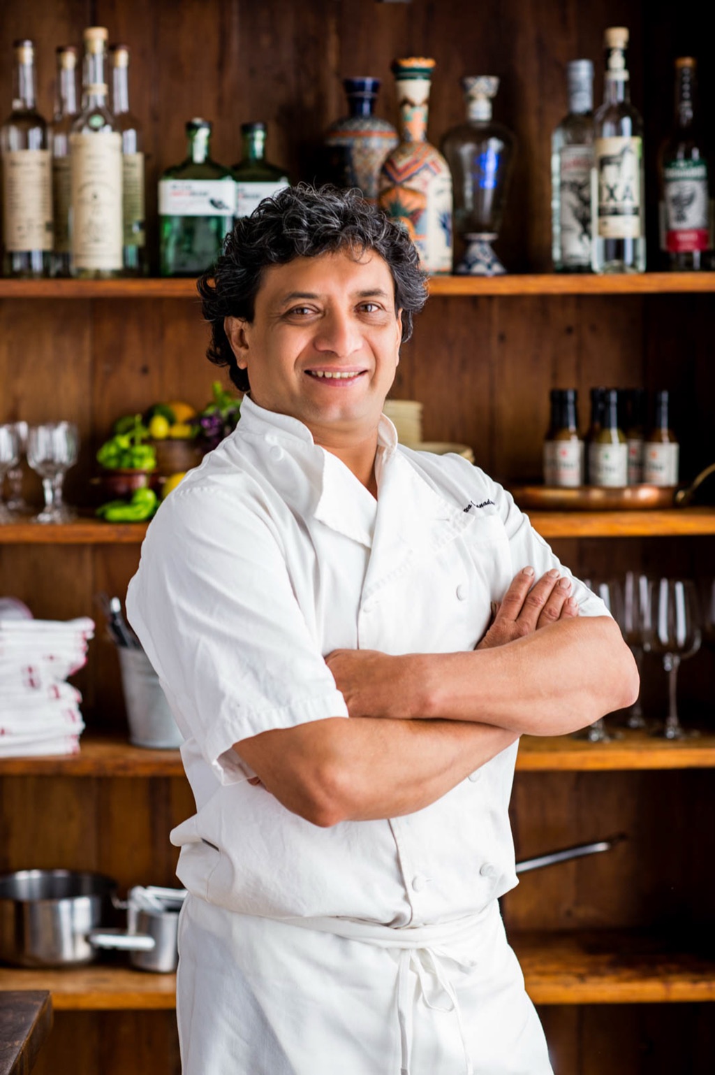 Portrait of a chef standing at an agave-lined restaurant bar