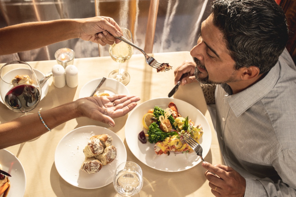 Couple sharing a bite of lobster at dinner