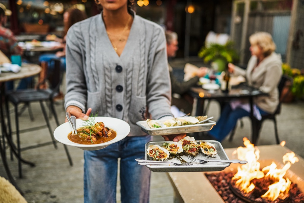 Oysters roasting over a fire pit during outdoor service