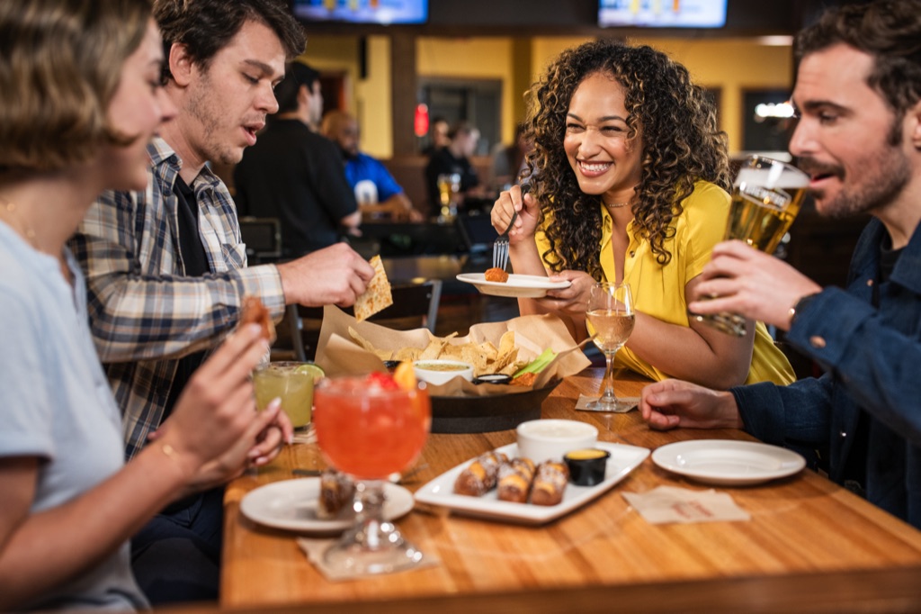 Friends sharing appetizers and drinks at a pub table