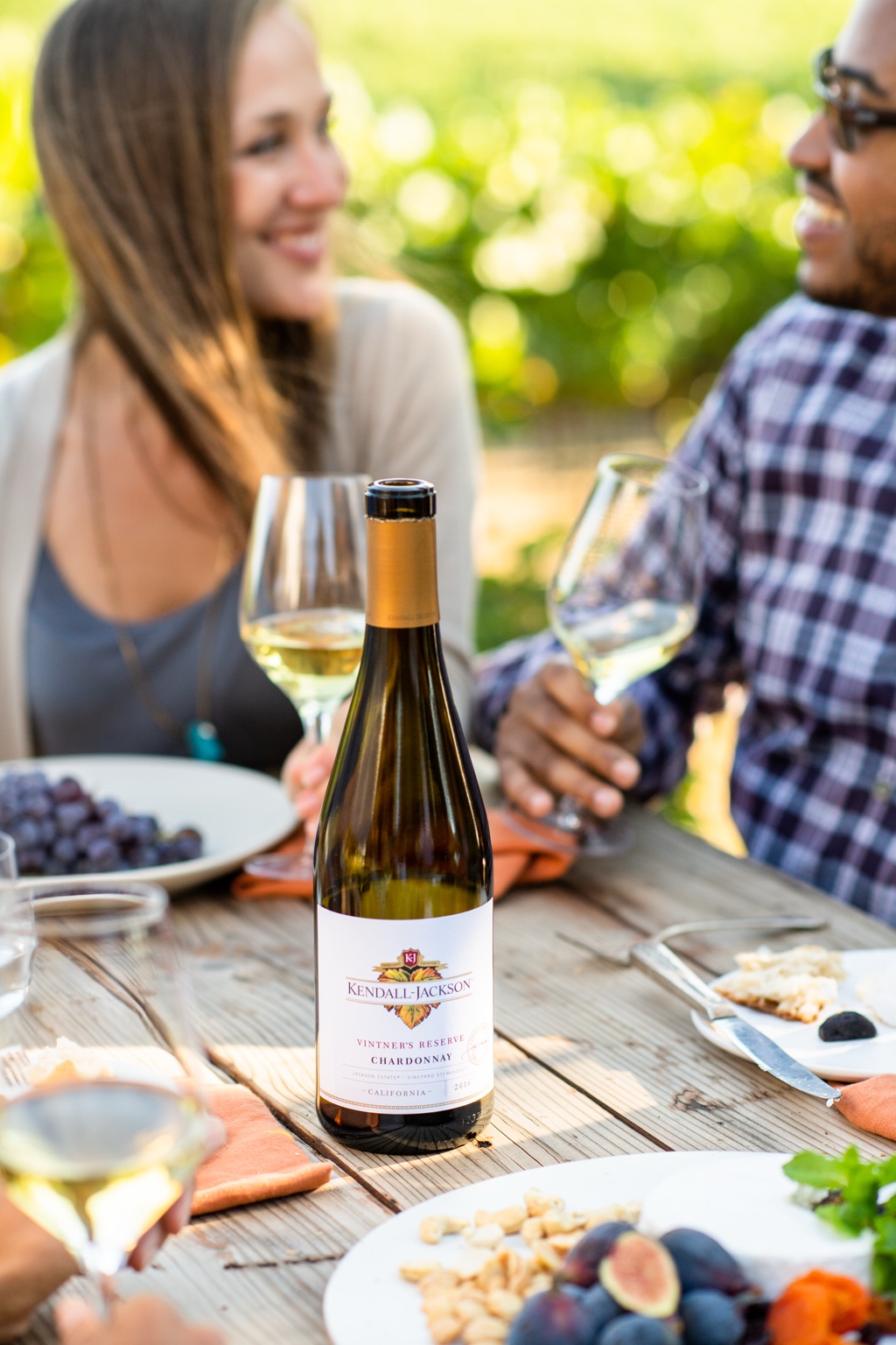 Kendall-Jackson Vintner's Reserve chardonnay on a vineyard picnic table between two friends