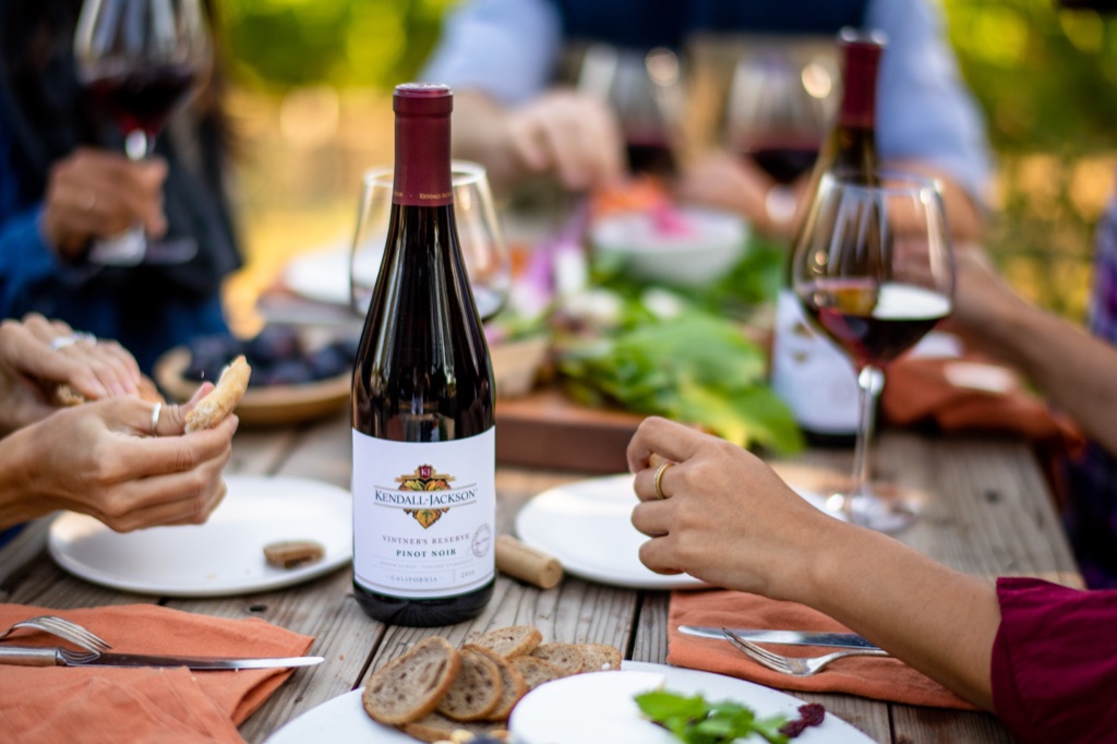 Kendall-Jackson Vintner's Reserve pinot noir at a wooden picnic table of small plates and red pours
