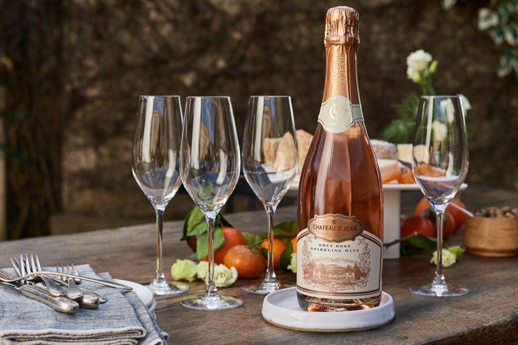 Sparkling rose and flutes on a garden stone table