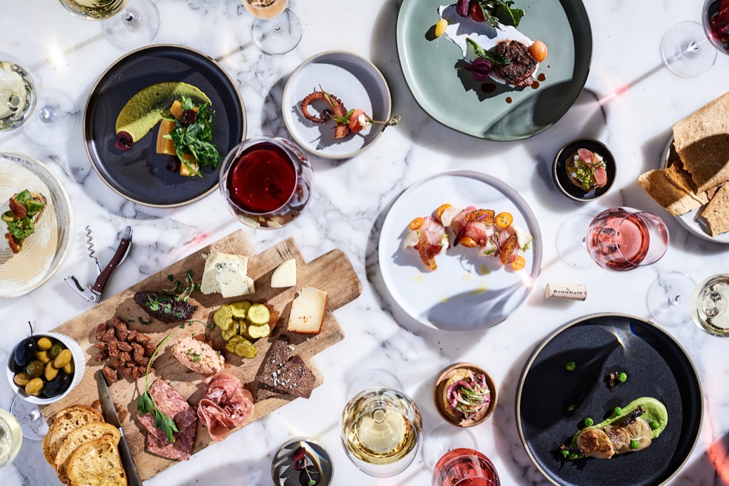 Overhead of a winery tasting menu spread on marble