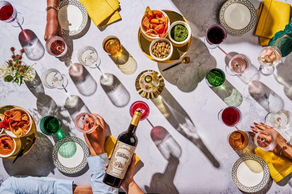 Overhead cocktail hour with a bottle of Bella Union Napa Valley red, rose, and snacks on marble