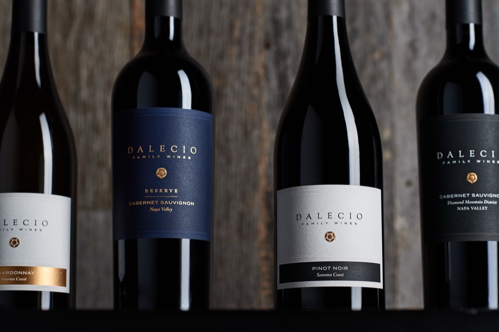 Dalecio Family Wines lineup of chardonnay, pinot noir, and cabernet bottles on weathered wood