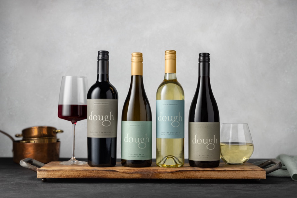 Dough Wines lineup of four bottles on a wooden board with copper pots